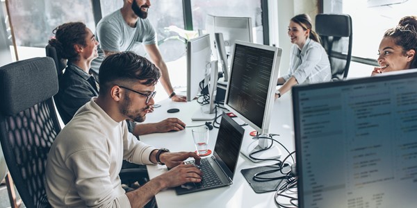 People around a table looking at their computers